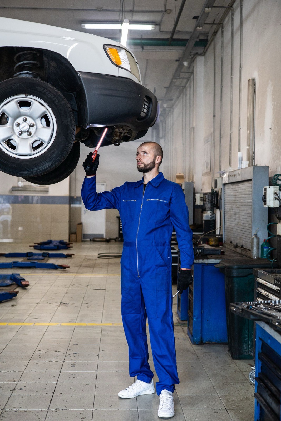 Technician inspecting the underside of a lifted vehicle