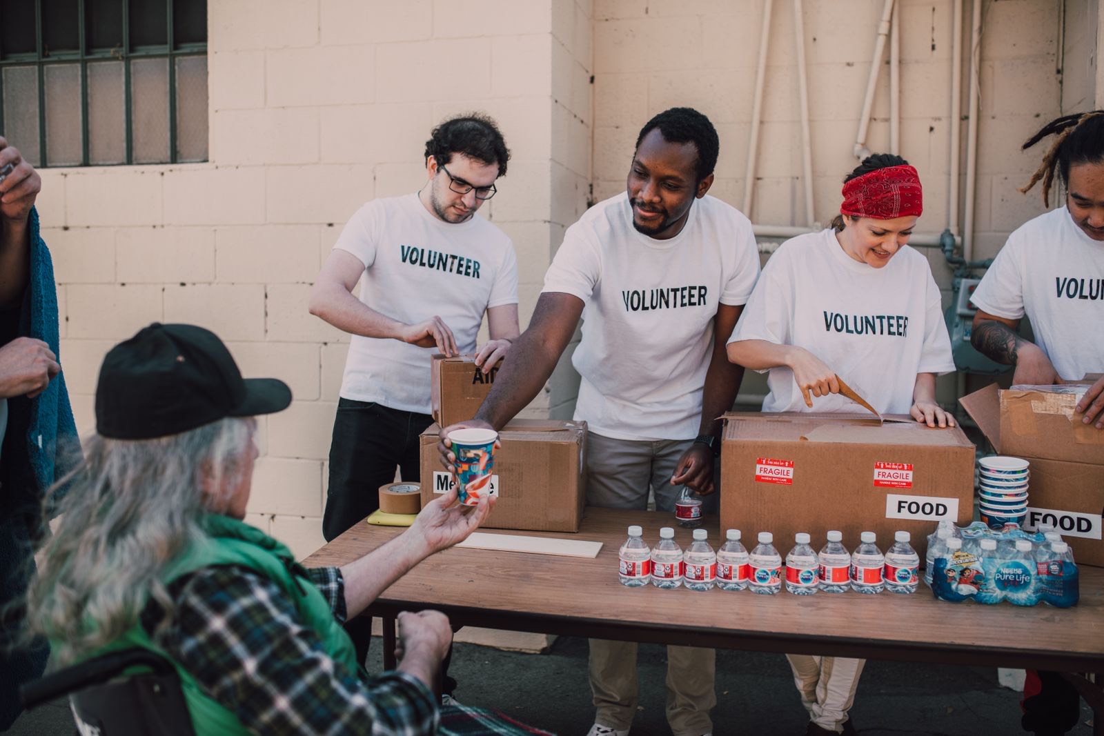 Volunteers handing out food and supplies at an outdoor community event