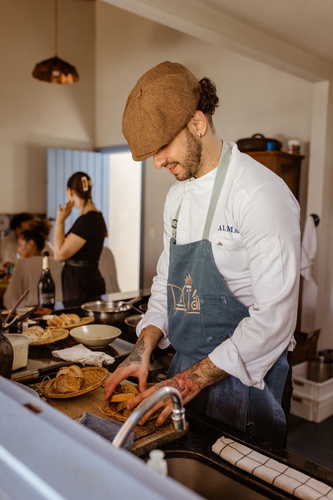 Chef plating in an open kitchen with guests seated nearby